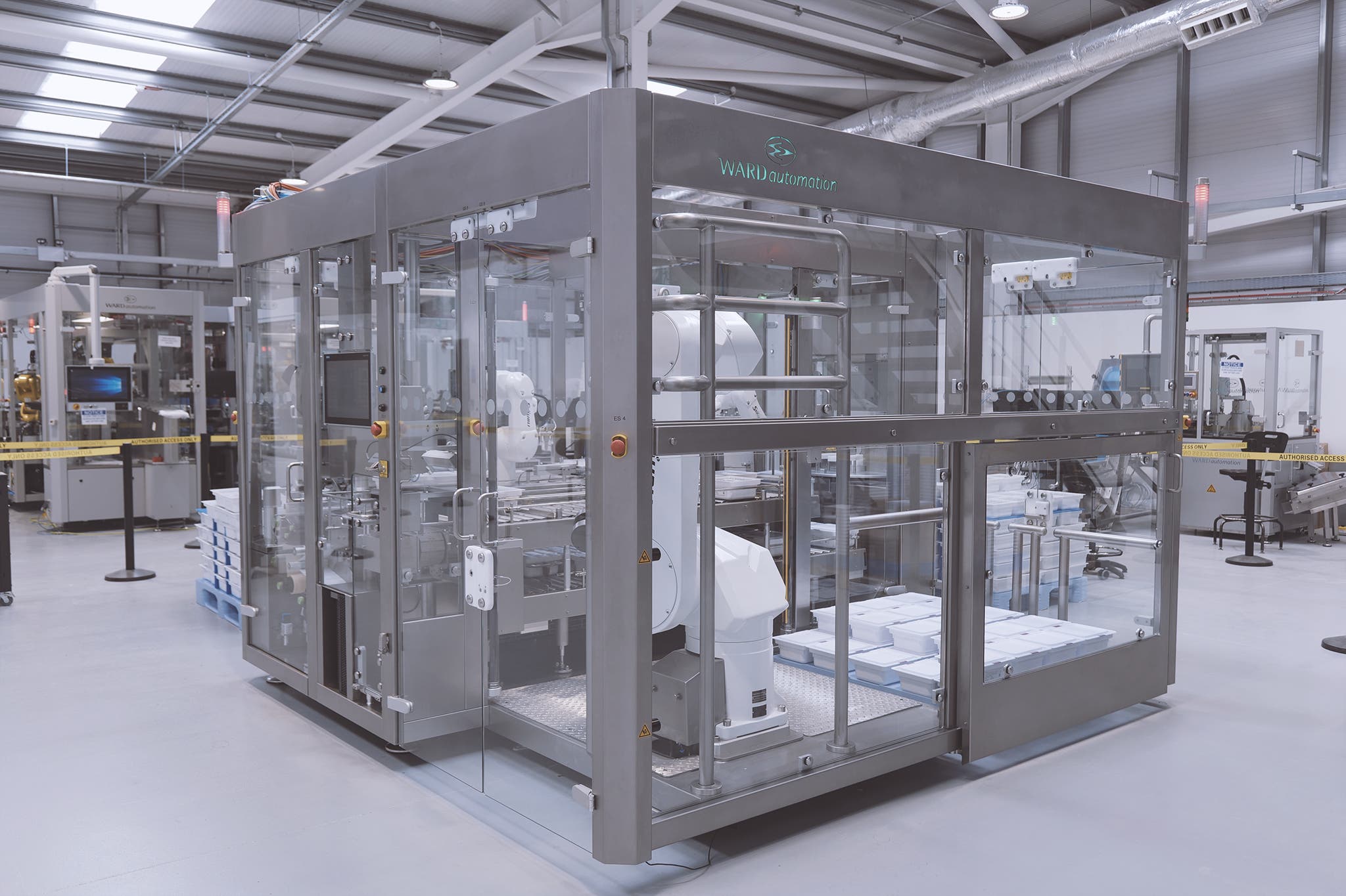 A compact cell: Three robots collaborate in inspecting and palletizing trays holding 100 syringes each